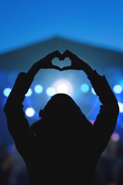 Onun en sevdiği grup için bir kalp-şekil sembol yapma kız