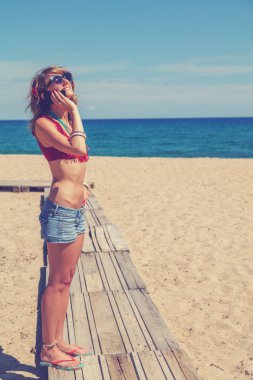 Açık havada akıllı telefon kullanan genç bir kadın.