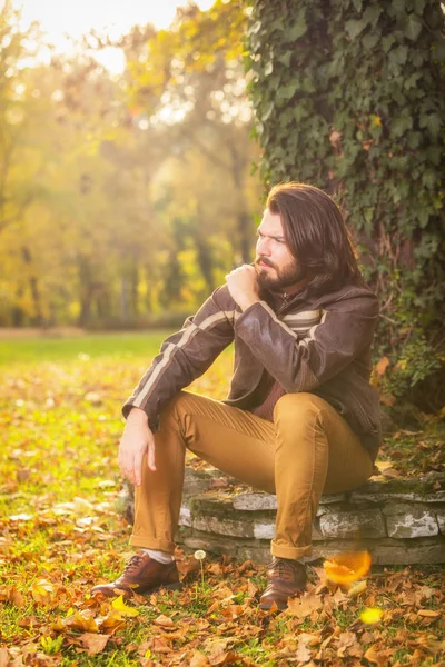 Sonbahar Ormanda Yakınındaki Taş Üzerinde Oturan Yakışıklı Adam — Stok fotoğraf