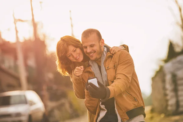 happy sweet couple taking selfie with smartphone outdoor