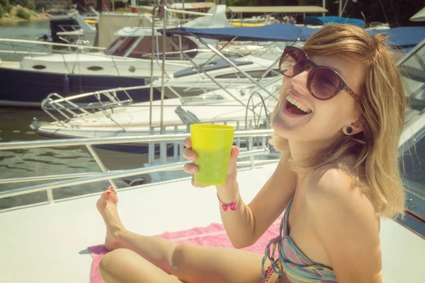 El yatta güneşli gün oturup kokteyl ile çekici kadın 