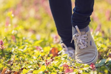 Çayırda, yürüyüş spor ayakkabı kadın bacaklarını açıp yakın çekim  