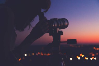 Geceleri bir teleskop kullanan kız