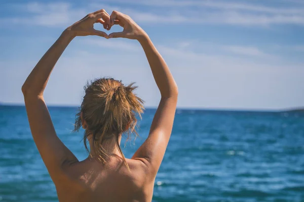 Kız Plajda Elleriyle Kalp Şekil Verme — Stok fotoğraf