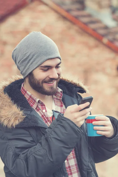 Hombre Sonriente Que Usa Ropa Abrigo Con Gorra Teléfono Inteligente —  Fotos de Stock