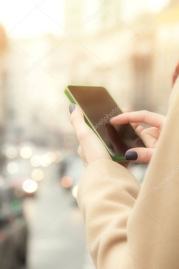 woman in beige coat using smartphone outdoor 