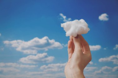 Bir bulut mavi gökyüzü arka plan üzerinde tutan eller