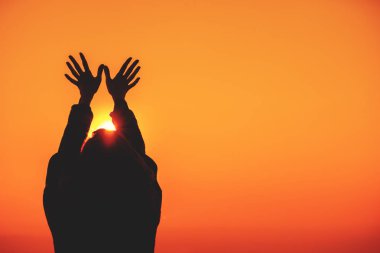 kadın günbatımı gökyüzü arka plan üzerinde ellerini kaldırdı 