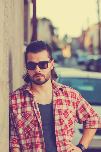 saç modeli güneş gözlüğü ve trendy kıyafetler bej duvar arka plan üzerinde poz ile yakışıklı adam 