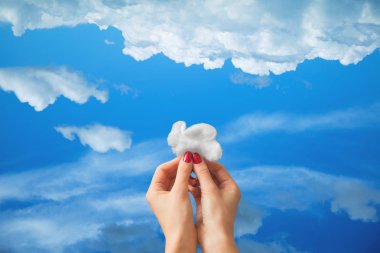 Bir bulut mavi gökyüzü arka plan üzerinde tutan eller