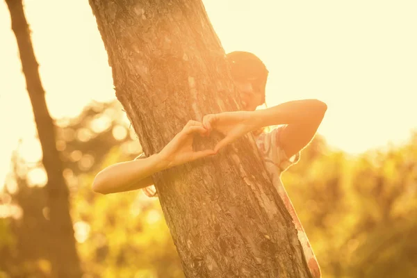 Parkta Ağaç Gövdesi Sarılma Sırasında Kalp Işaret Gösteren Kadın — Stok fotoğraf