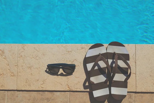 Flip Flops Und Sonnenbrille Der Nähe Des Schwimmbades — Stockfoto