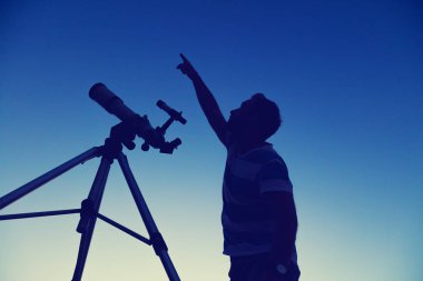 Genç adam geceleri bir teleskop kullanma