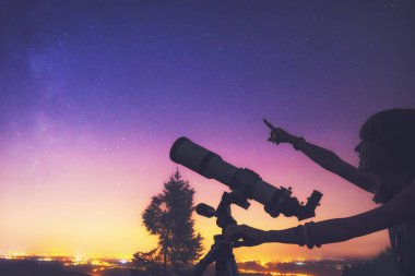 Geceleri bir teleskop kullanan kız