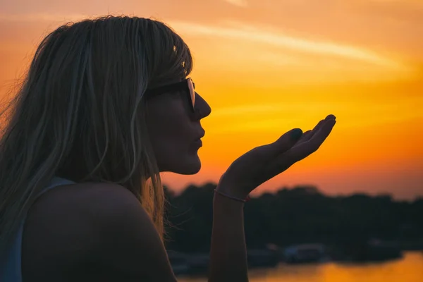 Жінка Сонцезахисних Окулярах Відправляє Повітряний Поцілунок Заході Сонця Фоні Неба — стокове фото