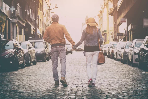 一对可爱的情侣牵着手走在街上的背面视图 — 图库照片
