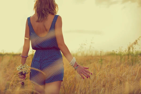 在阳光明媚的日子里 在草地上散步的时候 穿着蓝色衣服的女人带着一束鲜花抚摸着大麦的耳朵 — 图库照片