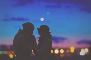 Romantik adam kız öpüşme gece şehir arka plan üzerinde eller 