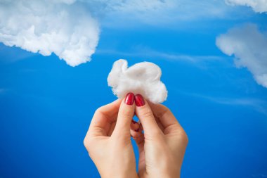 Bir bulut mavi gökyüzü arka plan üzerinde tutan eller