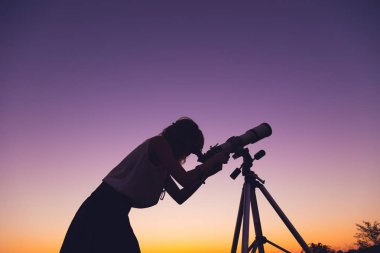 Geceleri bir teleskop kullanan kız