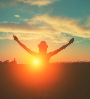 çayırda ayakta ve batımını kaldırdı elleriyle arkadan görünüşü kadın 