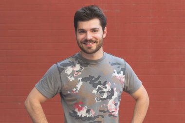 kırmızı tuğla duvar arka plan üzerinde poz mutlu gülümseyen adam portresi 