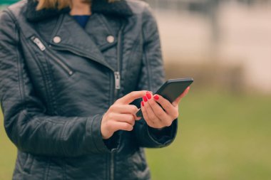 Eller kırmızı ile Smartphone cep telefonu ile açık, yakın çekim yazarak ileti manikür 