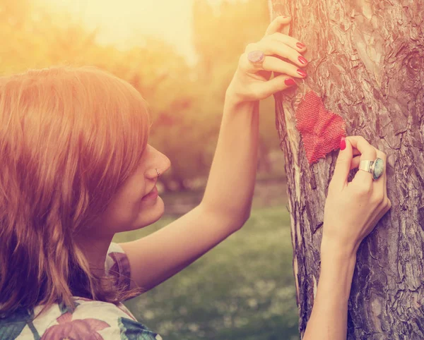 Dekoratif Kırmızı Kalp Ağaç Gövdesinde Koyarak Kadın — Stok fotoğraf