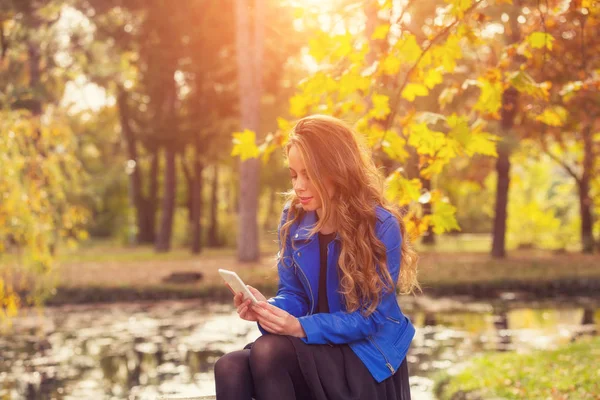 Lachende Prachtige Vrouw Met Behulp Van Smartphone Zittend Stenen Omheining — Stockfoto