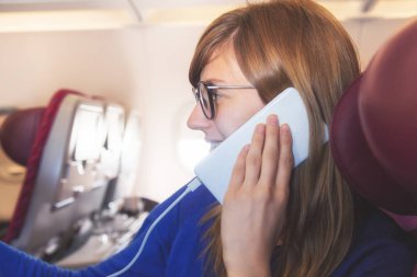 Uçağın içinde cep telefonu kullanan kız.