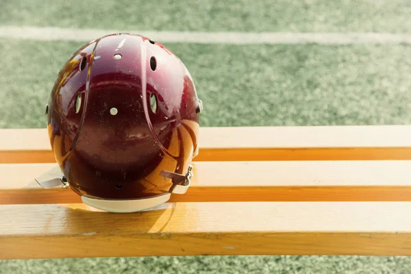 美式足球头盔在板凳上和运动场上 — 图库照片