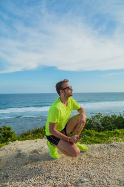 Koşucu / runner tutan bir cep telefonu kulaklıkları açık havada ile.