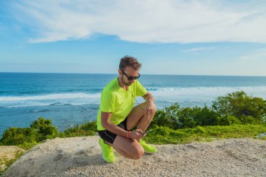 Koşucu / runner tutan bir cep telefonu kulaklıkları açık havada ile.