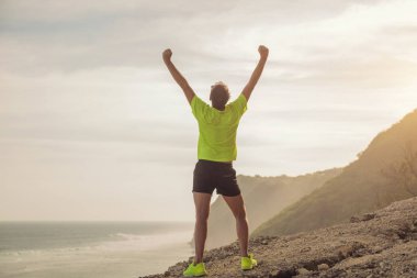 Koşu / denize yakın bir clif üzerinde egzersiz sonra bir adam başarısı / okyanus.