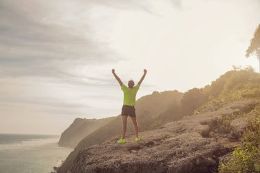 Koşu / denize yakın bir clif üzerinde egzersiz sonra bir adam başarısı / okyanus.