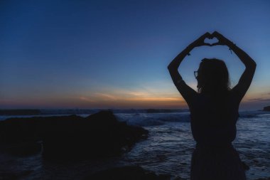 Okyanusta bir kalp şekli tutan kız / sea shore.