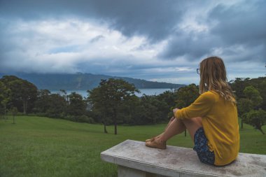 Bir bankta oturan ve manzara izlemek kadın.