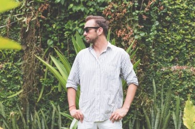 Güneş gözlüğü ve açık havada poz forması olan adam.