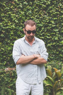 Güneş gözlüğü ve açık havada poz forması olan adam.