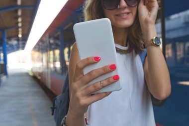 Bir tren istasyonunda cep telefonu kullanarak sevimli genç kız.