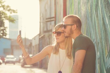 Çift alarak selfie Smartphone cep telefonu ile graffiti Duvar Street yakınındaki 