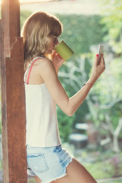 Lány Használja Mobilját Kávét Iszik Teát Kertben — Stock Fotó