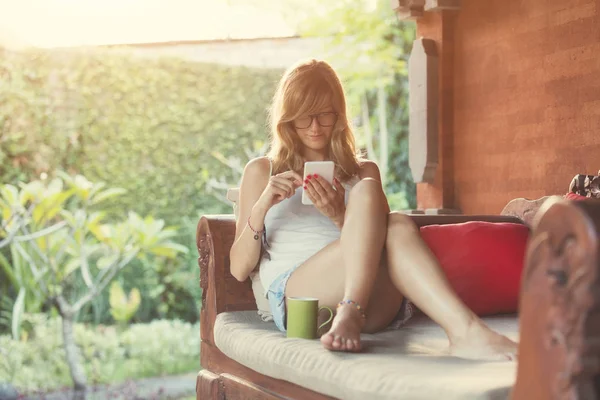 Ragazza Che Usa Cellulare Beve Caffè Sul Divano Giardino — Foto Stock