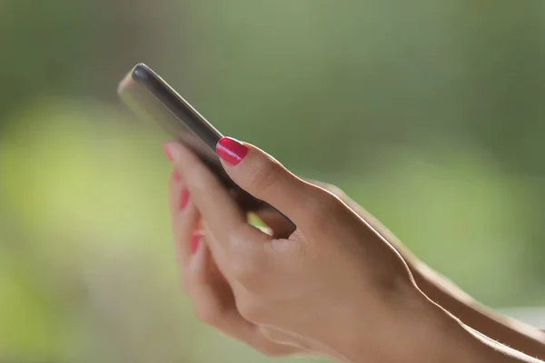 Vrouwelijke Handen Met Een Mobiele Telefoon Met Natuur Achtergrond — Stockfoto