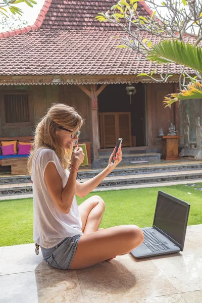 Chica Sosteniendo Teléfono Celular Taza Café Con Computadora Portátil Porche — Foto de Stock