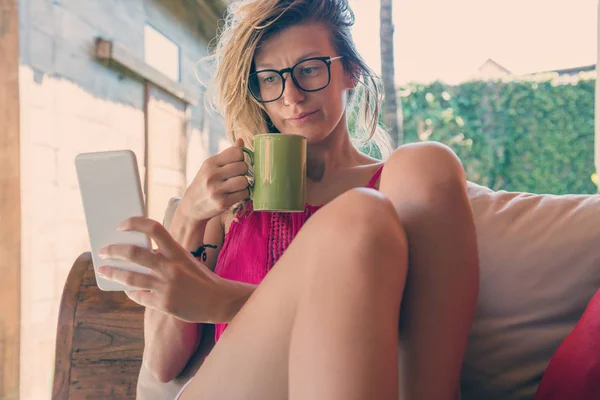 Κορίτσι Ανάγνωση Ειδήσεων Ένα Έξυπνο Τηλέφωνο Και Πίνοντας Καφέ Πρωί — Φωτογραφία Αρχείου