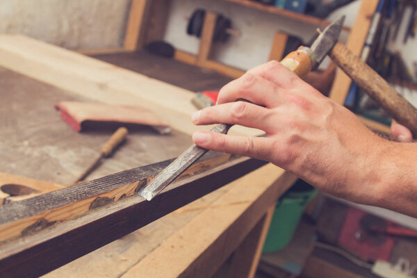 Male carpenter working on raw wood / boards / plank.