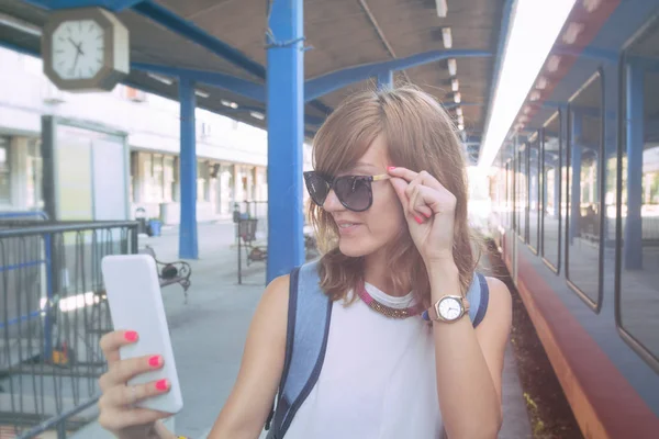 Χαριτωμένο Νεαρή Κοπέλα Χρησιμοποιώντας Κινητό Τηλέφωνο Ένα Σιδηροδρομικό Σταθμό — Φωτογραφία Αρχείου