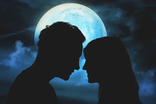 Ay ışığının aydınlattığı gökyüzü altında genç bir çiftin siluetleri.