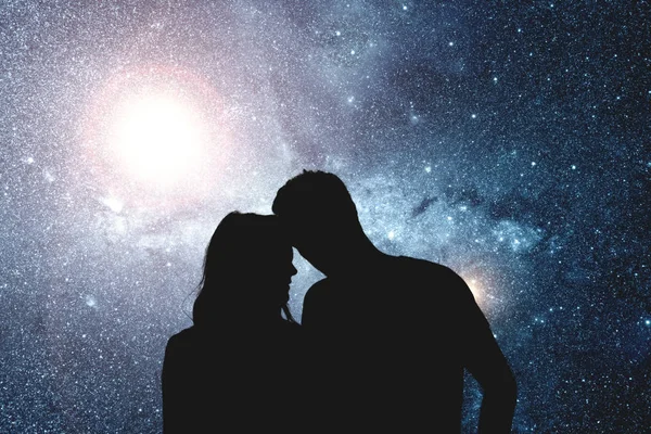 星光灿烂的天空下的一对年轻情侣的剪影 — 图库照片